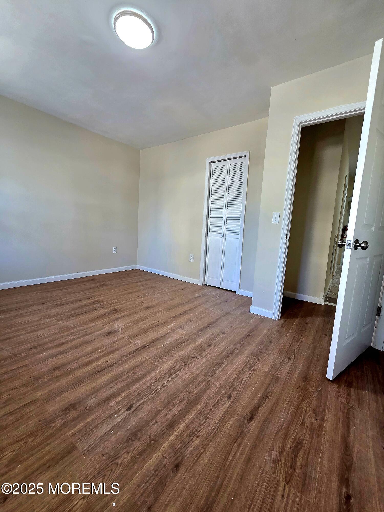 216 Delaware Street Elizabeth Port, NJ 07206 - Photo 22 of 40 an empty room with wooden floor and closet