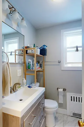 a bathroom with a sink toilet and a mirror