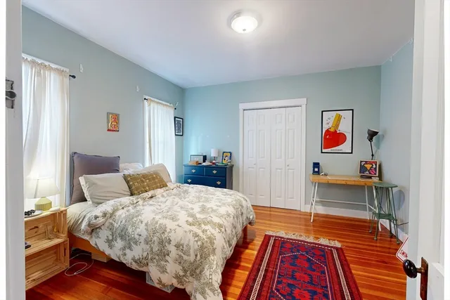 a bedroom with bed and wooden floor