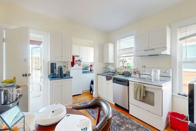 a kitchen with stainless steel appliances white cabinets and a window