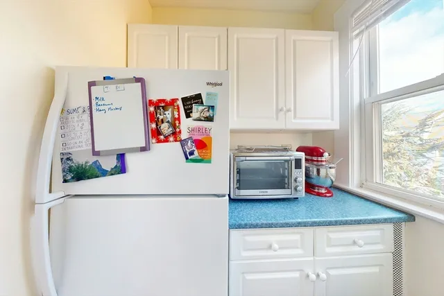 a white kitchen with a sink and white cabinets