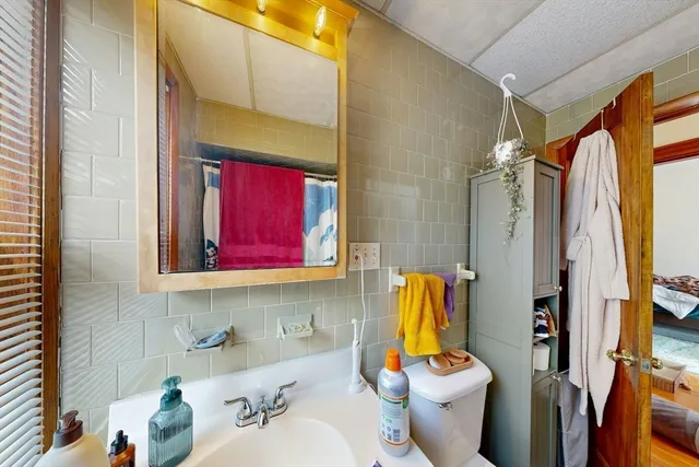 a bathroom with a sink toilet and mirror