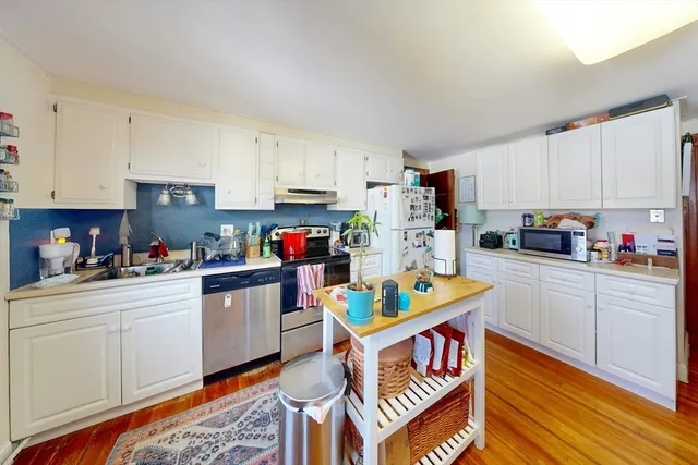 a kitchen with granite countertop a sink stove and cabinets