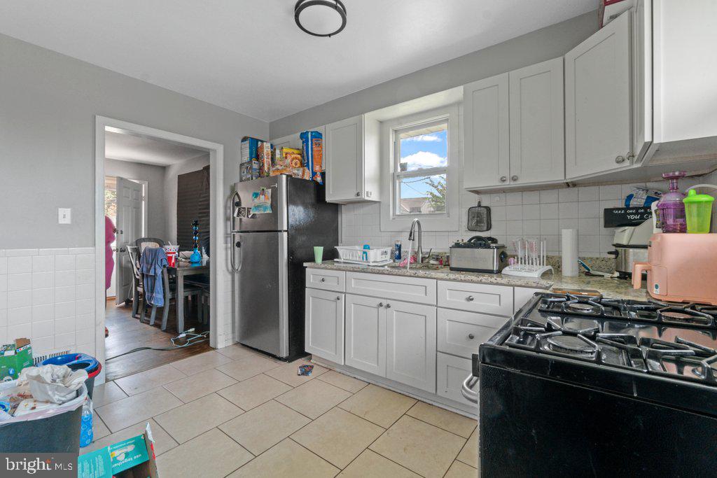 6611 Windsor Mill Road Baltimore, MD 21207 - Photo 4 of 11 a kitchen with refrigerator and cabinets