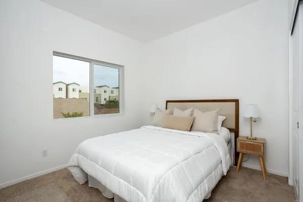 a bedroom with a bed and painting on the wall