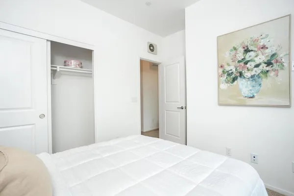 a bedroom with a bed and a painting on the wall