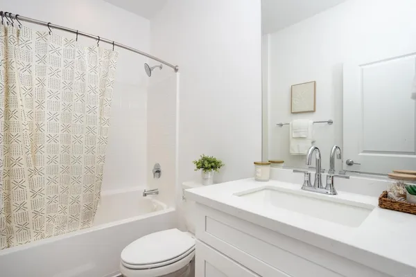 a bathroom with a granite countertop sink a toilet and shower