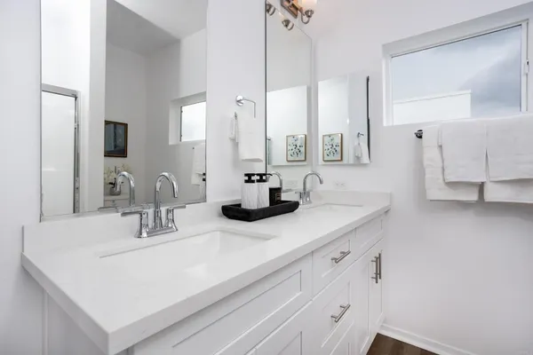 a bathroom with double vanity sink and mirror
