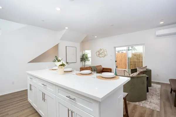 a view of a kitchen area kitchen island dining room wooden floor and living room