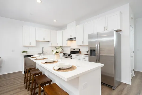 a kitchen with refrigerator cabinets dining table and chairs