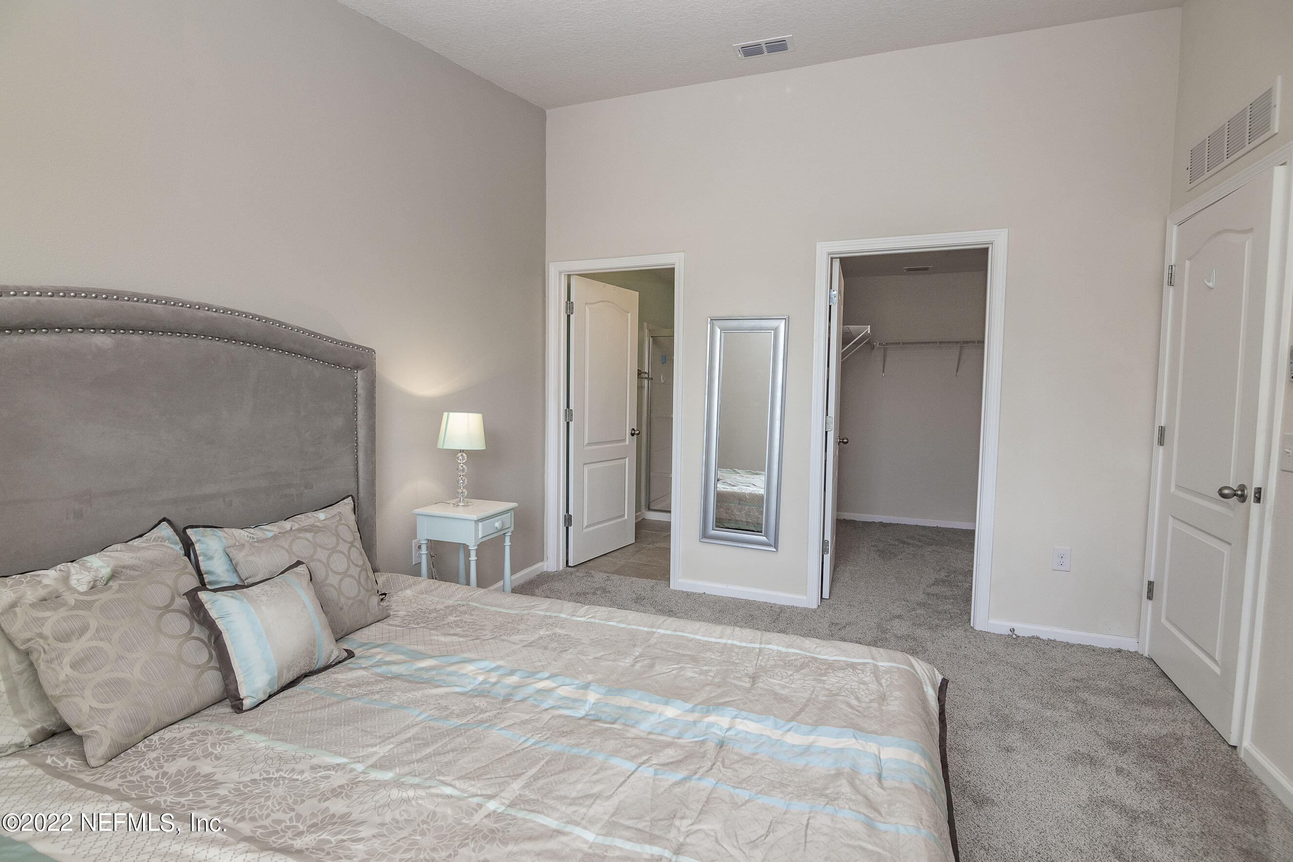 803 Golden Lake Loop St. Augustine, FL 32084 - Photo 16 of 33 a large bedroom with a bed and lamp