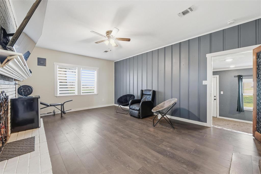 379 Private Road, Unit 4650 Boyd, TX 76023 - Photo 11 of 40 Living area featuring dark wood finished floors, plenty of natural light, an accent wall, a ceiling fan, and a decorative wall