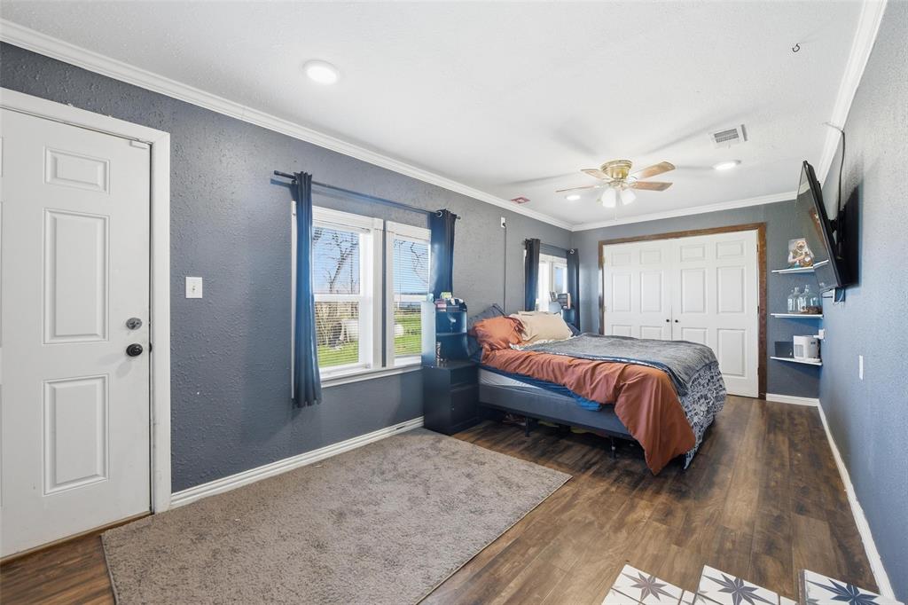 379 Private Road, Unit 4650 Boyd, TX 76023 - Photo 21 of 40 Bedroom featuring crown molding, a closet, dark wood finished floors, a textured wall, and ceiling fan