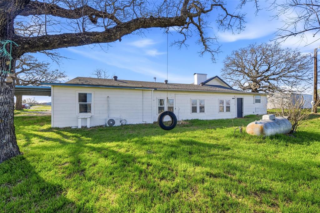 379 Private Road, Unit 4650 Boyd, TX 76023 - Photo 36 of 40 Back of property featuring a chimney and a lawn