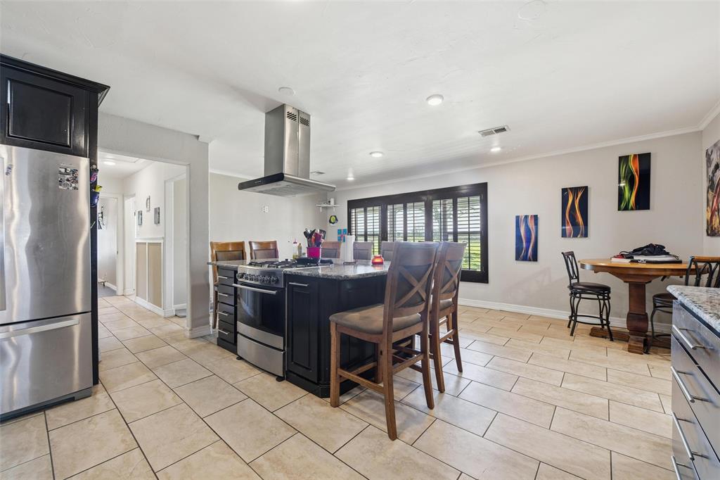 379 Private Road, Unit 4650 Boyd, TX 76023 - Photo 5 of 40 Kitchen with dark cabinets, stainless steel appliances, island exhaust hood, dark stone countertops, and a kitchen island