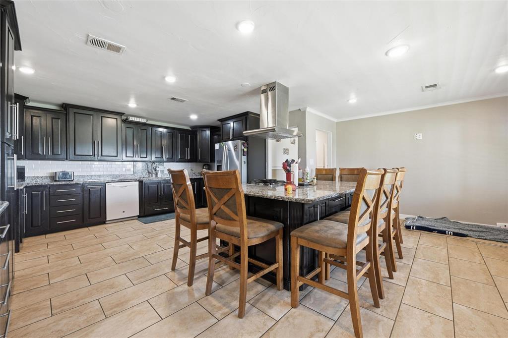 379 Private Road, Unit 4650 Boyd, TX 76023 - Photo 6 of 40 Kitchen with dark cabinets, light stone counters, tasteful backsplash, a kitchen breakfast bar, and extractor fan
