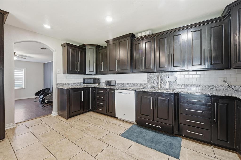 379 Private Road, Unit 4650 Boyd, TX 76023 - Photo 7 of 40 Kitchen featuring backsplash, arched walkways, white dishwasher, light stone countertops, and stainless steel microwave