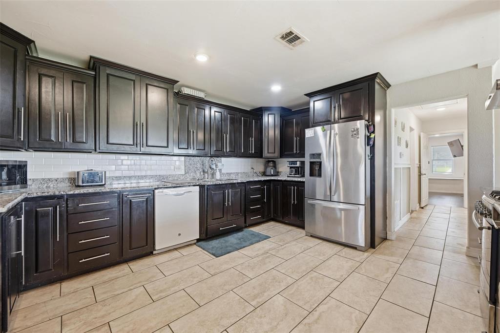 379 Private Road, Unit 4650 Boyd, TX 76023 - Photo 8 of 40 Kitchen with stainless steel appliances, light stone countertops, backsplash, dark wood finish cabinetry, and recessed lighting