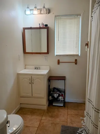 a bathroom with a toilet sink and mirror