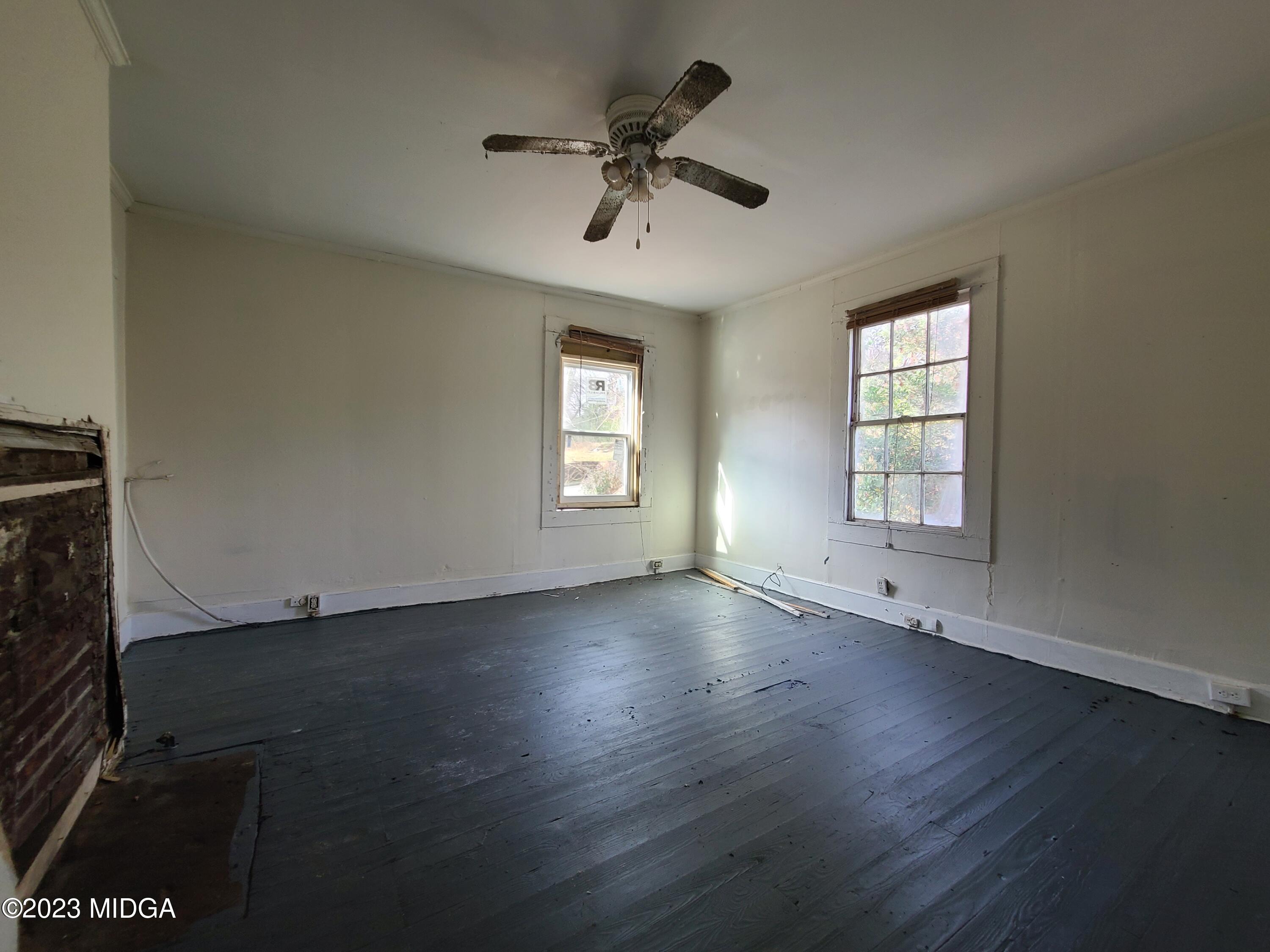 424 Pansy Avenue Macon, GA 31204 - Photo 16 of 19 an empty room with wooden floor chandelier fan and windows