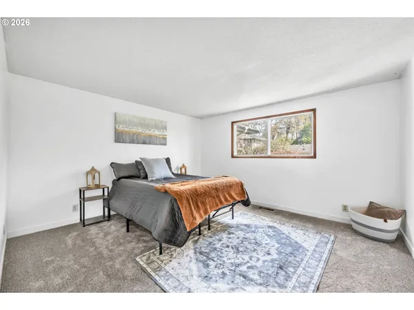 a living room with a bed furniture and next to a window