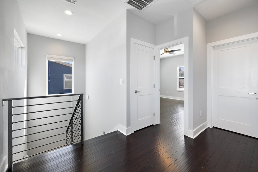6301 Santos Street, Unit A Austin, TX 78741 - Photo 24 of 37 an empty room with wooden floor mirror and windows