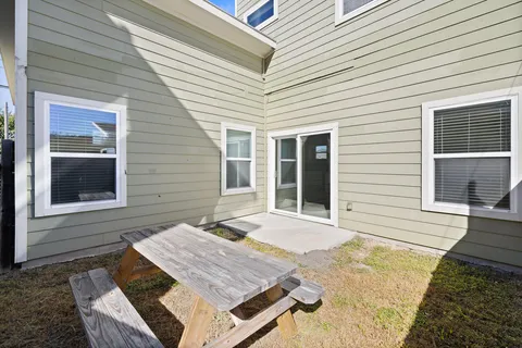 a view of a patio with table and chairs with wooden floor and fence