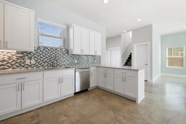 a kitchen with granite countertop white cabinets and white appliances