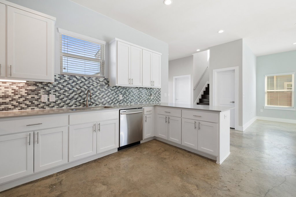 6301 Santos Street, Unit A Austin, TX 78741 - Photo 9 of 37 a kitchen with granite countertop white cabinets and white appliances