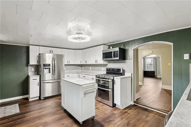 a kitchen with white cabinets and stainless steel appliances