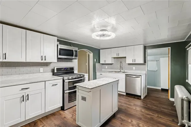 a kitchen with stainless steel appliances granite countertop a stove sink and cabinets