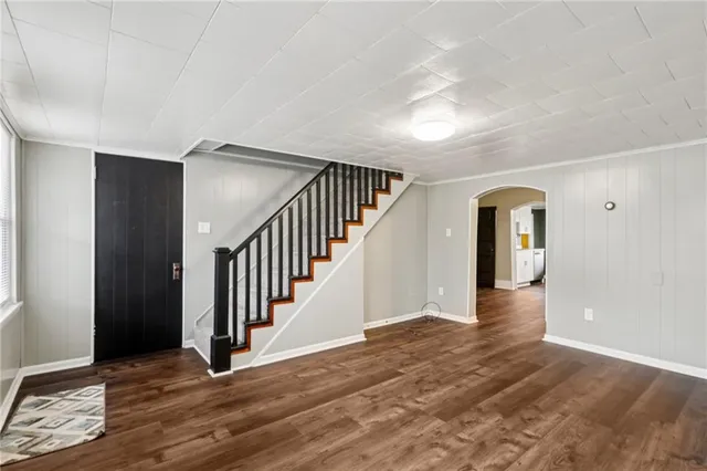a view of an empty room with wooden floor and windows