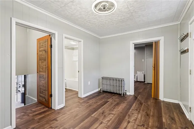 a view of a hallway with wooden floor and closet