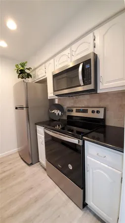 a kitchen with stainless steel appliances a stove a microwave and a refrigerator