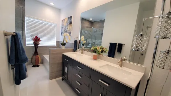 a bathroom with a double vanity sink a mirror and a shower