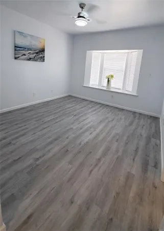 an empty room with wooden floor and window