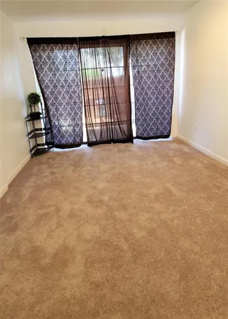 an empty room with a wooden floor and large window