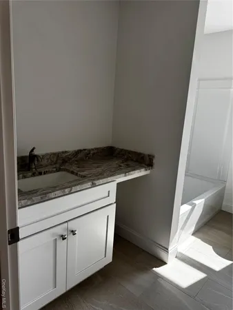 a view of an empty room with wooden floor and closet