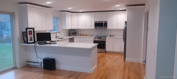 a large kitchen with a sink stainless steel appliances and counter space