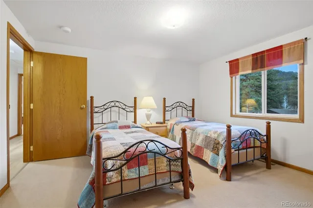 a bedroom with two beds and window