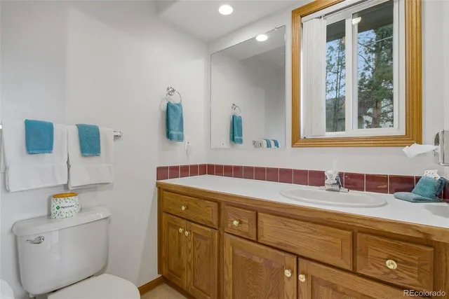 a bathroom with a toilet sink and mirror