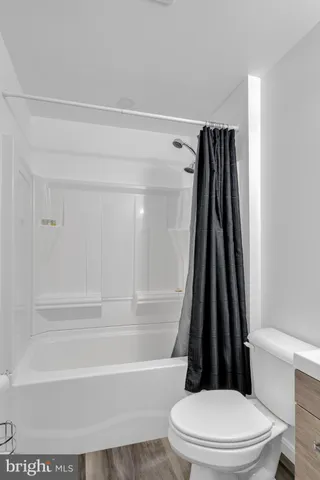 a bathroom with a toilet and a shower curtain