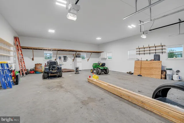 a view of a white house with a small yard and wooden fence