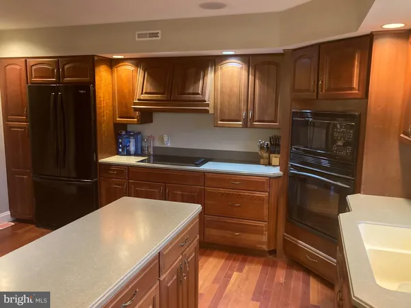 a large kitchen with stainless steel appliances granite countertop a large stove a sink dishwasher and cabinets with wooden floor