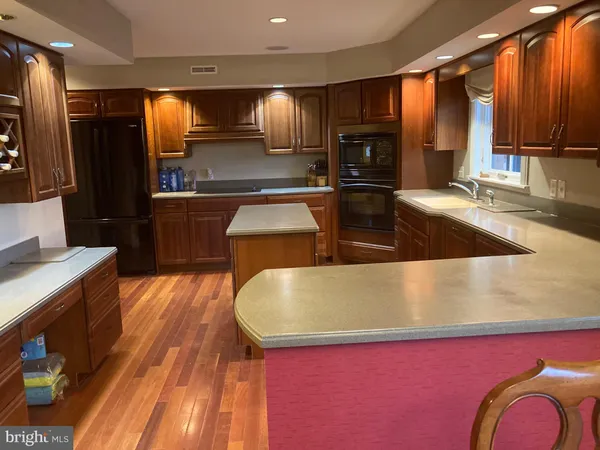 a kitchen with stainless steel appliances granite countertop wooden cabinets a sink and a large window