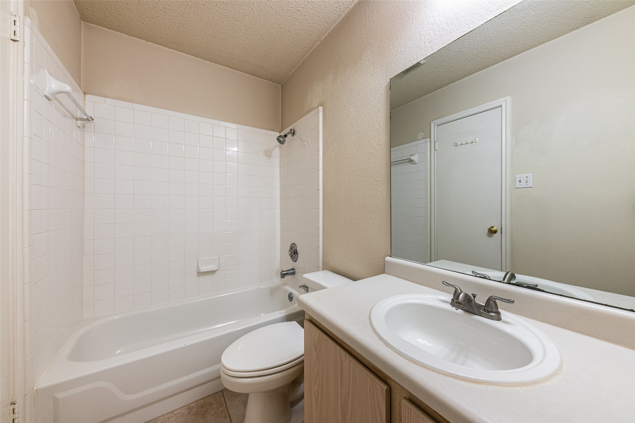 7216 Aldea Drive, Unit A Austin, TX 78745 - Photo 20 of 25 Full bathroom featuring a white tub, shower with white tile surround, and a vanity with an integrated sink
