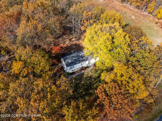 an empty room with chandelier fan and windows