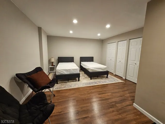 a living room with couches chairs and wooden floor