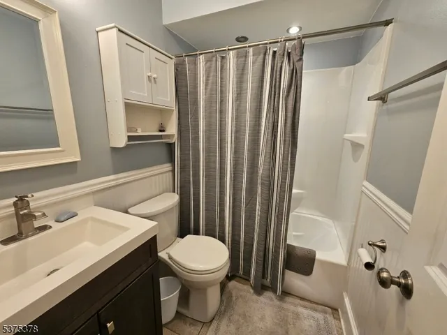 a bathroom with a sink a toilet a mirror and shower