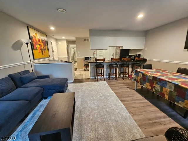 a living room with lots of furniture and kitchen view